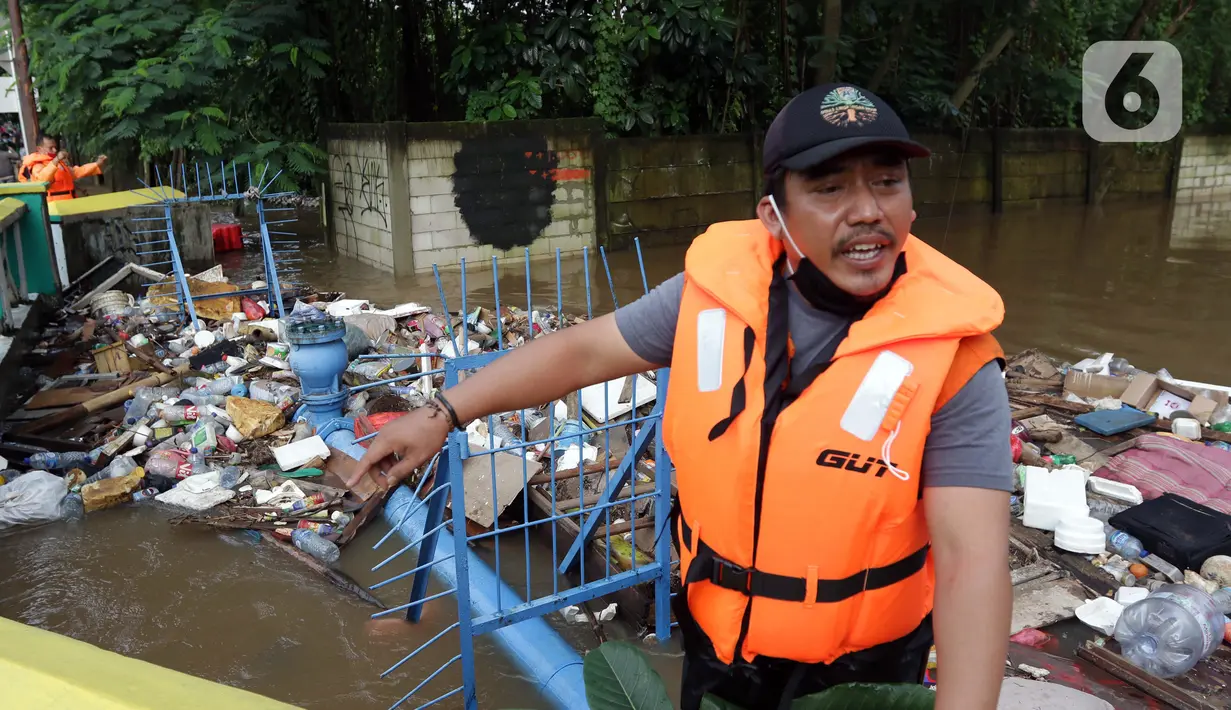 Petugas UPK Badan Air DLH Provinsi DKI Jakarta berjibaku membersihkan tumpukan sampah yang menghalangi aliran air Kali Mampang di Jalan Pejaten Raya, Jakarta, Sabtu (20/2/2021). Aliran air Kali Mapang di Jalan Pejaten Raya meluap akibat sumbatan tumpukan sampah. (Liputan6.com/Helmi Fithriansyah)