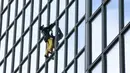 Alain Robert ketika memanjat gedung di pusat bisnis La Defense, Paris, Prancis, Senin (21/3/2016). Pria yang dijuluki 'Spiderman' ini telah memanjat lebih dari 70 gedung tertinggi di dunia. (Jacques DEMARTHON/AFP)