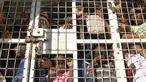 Warga Haiti yang ditahan untuk dideportasi berdiri di sebuah truk polisi di jembatan perbatasan antara Dajabon, Republik Dominika, dan Haiti, Rabu, 11 Oktober 2023. (AP Photo/Ricardo Hernandez)