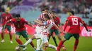 Bek Maroko, Achraf Hakimi berusaha melewati gelandang Kroasia, Luka Modric selama pertandingan playoff perebutan peringkat ketiga Piala Dunia 2022 di Khalifa International Stadium di Doha, Qatar, Sabtu (17/12/2022). Kroasia meraih juara ketiga Piala Dunia 2022 usai menang 2-1 atas Maroko. (AP Photo/Hassan Ammar)