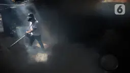 Petugas melakukan pengasapan atau fogging untuk membasmi nyamuk demam berdarah dengue (DBD) di kawasan Rumah Penduduk Simprug, Kebayoran Lama, Jakarta Selatan, Senin (28/12/2019). Sepanjang Tahun 2020 DBD di Indonesia mencapai 95.893 Kasus DBD. (Liputan6.com/Johan Tallo)