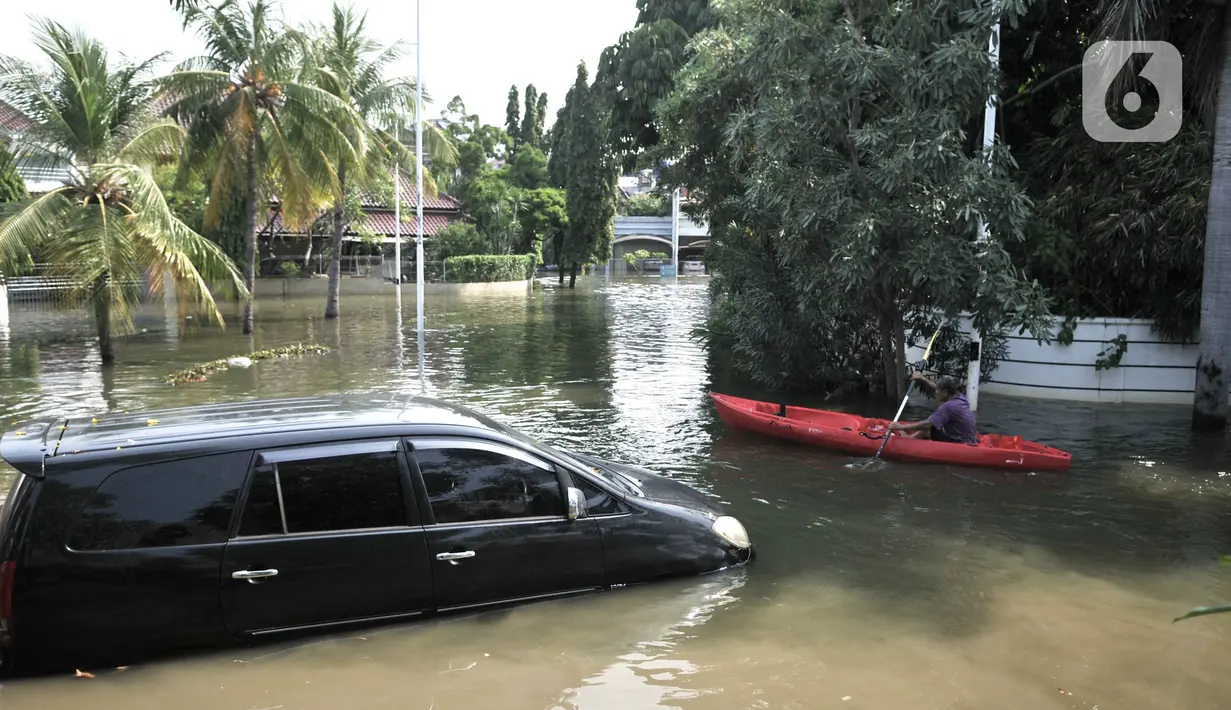 Warga beraktivitas menggunakan perahu melintasi mobil terendam banjir rob di Kompleks Perumahan Pantai Mutiara, Pluit, Jakarta, Minggu (7/6/2020). (merdeka.com/Iqbal S. Nugroho)