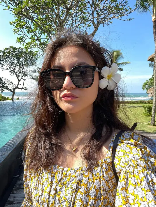 Kacamata rupanya menjadi fashion item favorit ketika liburan, tak terkecuali dengan Marsha Aruan. Artis kelahiran 24 Oktober 1996 ini semakin cantik dengan bunga kamboja warna putih yang terselip di telinganya. Baju motif bunga berwarna kuning yang dikenakannnya juga mendukung penampilannya. (Liputan6.com/IG/@aruanmarsha)