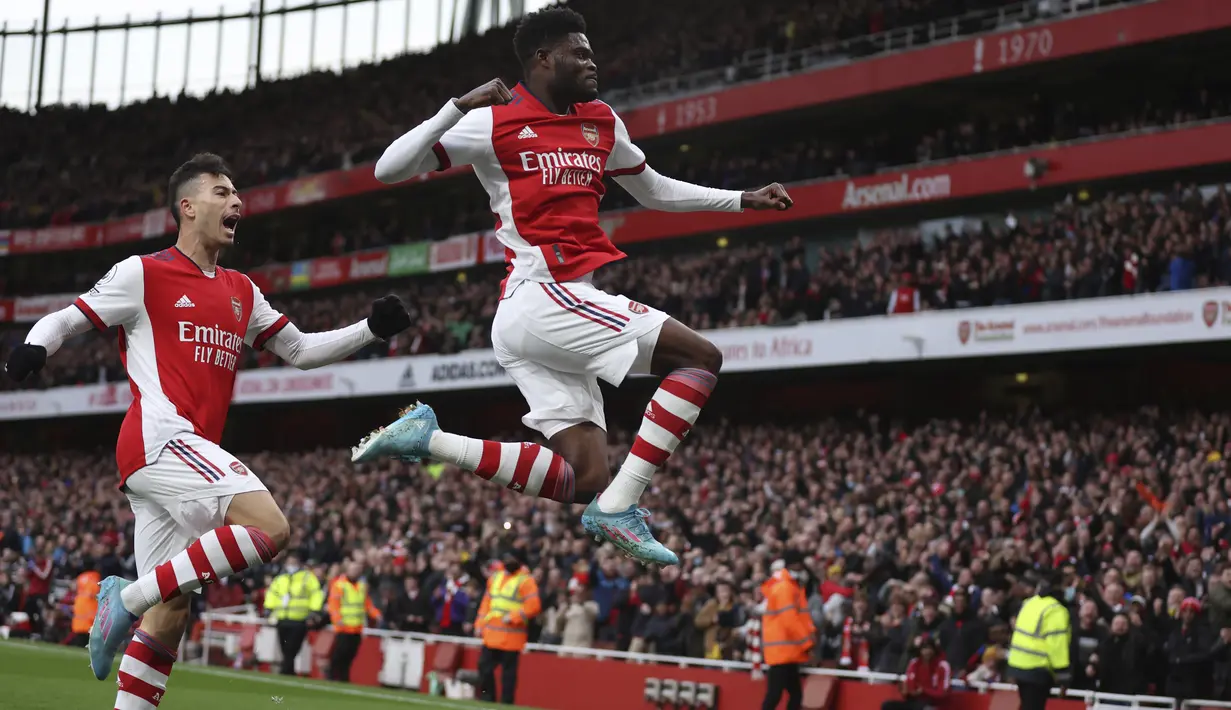 Gelandang Arsenal, Thomas Partey (kanan) berselebrasi usai mencetak gol ke gawang Leicester City pada pertandingan lanjutan Liga Inggris di Stadion Emirates, di London, Senin (14/3/2022). Berkat kemenangan ini Arsenal kembali naik ke peringkat empat klasemen sementara. (AP Photo/Ian Walton)
