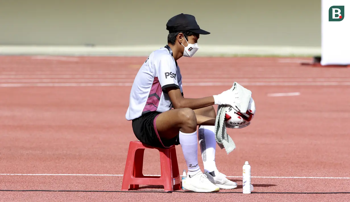 Anak gawang mengelap bola sebelum pertandingan antara Persikabo 1973 melawan Arema FC pada laga Piala Menpora di Stadion Manahan, Solo, Minggu (21/3/2021). (Bola.com/M Iqbal Ichsan)