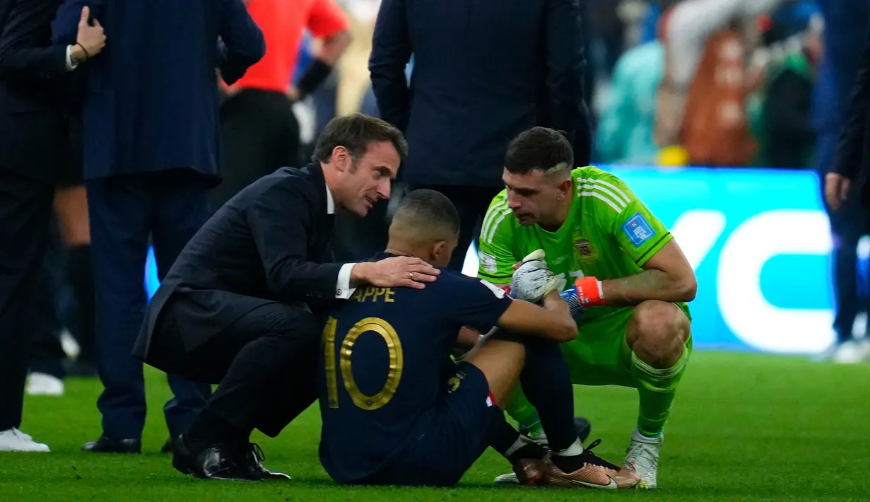 Presiden Prancis Emmanuel Macron (kiri) dan kiper Emiliano Martinez (kanan) menghibur Kylian Mbappe (tengah) usai melawan Argentina pada pertandingan sepak bola final Piala Dunia 2022 di Stadion Lusail, Lusail, Qatar, 18 Desember 2022. Argentina menang 4-2 dalam adu penalti melawan Prancis setelah pertandingan berakhir imbang 3 -3. (AP Photo/Natacha Pisarenko)