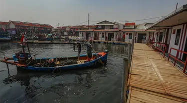 Nelayan membawa kerang hijau usai melaut ke rumahnya yang sudah direnovasi menjadi rumah apung  di Kampung Nelayan Muara Angke, Jakarta Utara, Rabu (14/8/2024). (merdeka.com/Arie Basuki)