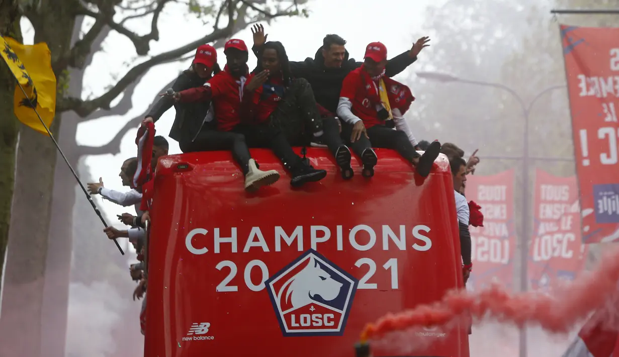 Para pemain Lille melambai kepada para penggemar dari atas bus atap terbuka saat merayakan juara Juara Ligue 1 Prancis di Lille, Prancis utara (24/5/2021). Lille tampil sebagai juara Ligue 1 Prancis musim 2020-2021, menghentikan dominasi Paris Saint-Germain. (AP Photo/Michel Spingler)