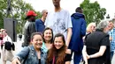 Wisatawan berswafoto dengan Brahim Takioullah dari Prancis (2,46) di Champs-Elysees Avenue, Paris, 1 Juni 2018. Belasan pria tertinggi di dunia bertemu pada akhir pekan di ibu kota Prancis. (AFP/GERARD JULIEN)