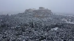 Bukit Acropolis kuno tertutup salju di Athena, Yunani, Senin (24/1/2022). Hujan salju lebat telah mengganggu lalu lintas udara di Athena dan kota tetangga terbesar di Turki, Istanbul, sementara beberapa pulau Aegea dan sebagian besar wilayah Turki diselimuti oleh salju.  (AP Photo/Michael Varaklas)