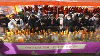 Para orangtua meletakkan lilin selama kebaktian khusus untuk mendoakan keberhasilan anak-anak mereka dalam ujian masuk perguruan tinggi di Kuil Buddha Jogyesa, Seoul, Korea Selatan, Kamis (3/12/2020). Ujian diikuti ratusan ribu siswa, termasuk puluhan siswa pasien COVID-19. (AP Photo/Ahn Young-joon)