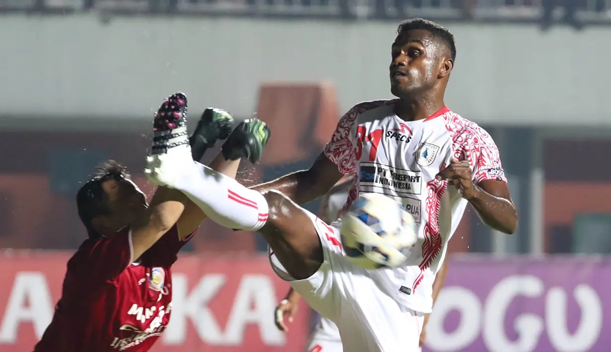 Pemain Persipura, Dominggus Fakdawer, berusaha membobol gawang Arema Cronus yang dijaga Made Wardana pada babak 8 besar Piala Jenderal Sudirman di Stadion Maguwoharjo, Sleman, Minggu (13/12/2015). (Bola.com/Nick Hanoatubun)