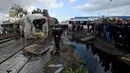 Sejumlah orang berkumpul di lokasi kecelakaan antara kereta dengan sebuah bus di rel dekat wilayah Sidi Fathallah, sekitar 10 km selatan Ibu Kota Tunisia, Rabu (28/12). Penyelidikan tengah dilakukan untuk mencari tahu apa yang terjadi. (Fethi Belaid/AFP)