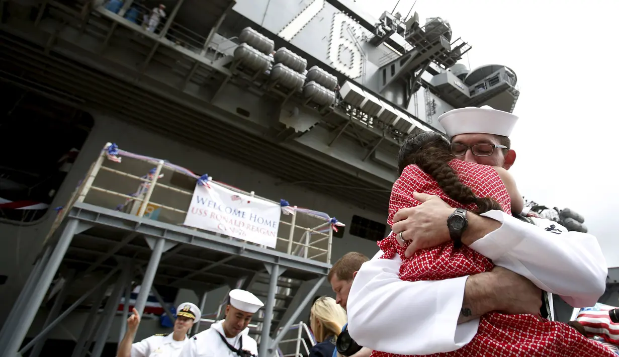 Keluarga para awak kapal menyambut kedatangan USS Ronald Reagan saat tiba di pangkalan angkatan laut Yokosuka, Tokyo, Jepang, (1/10/2015). USS Ronald Reagan tiba di Jepang sehari lebih awal dari yang dijadwalkan. (REUTERS/Yuya Shino)