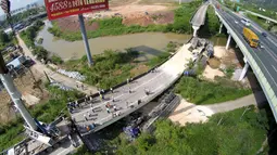 Sejumlah warga melihat kondisi jalan layang yang ambruk dan kendaraan yang terjatuh di Heyuan, Guangdong, China, (19/6/2015). Menurut media setempat, penyebab runtuhnya jalan layang tersebut masih dalam penyelidikan. (REUTERS/Stringer)