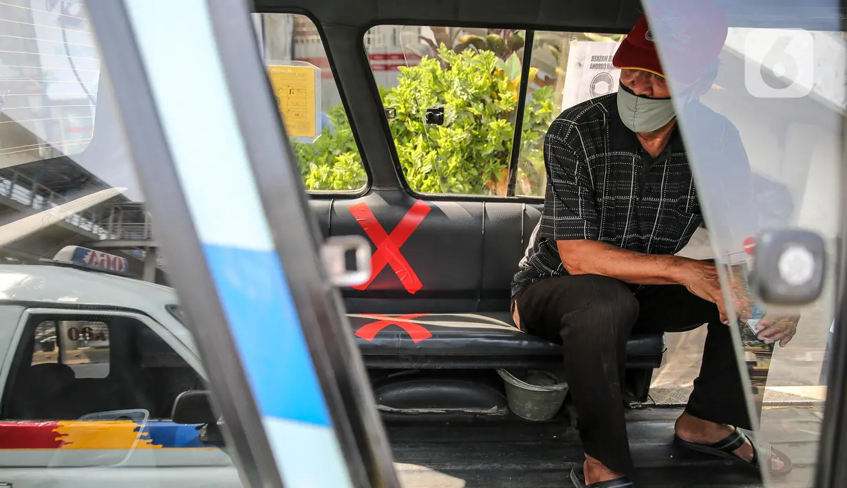 Penumpang menerapkan jaga jarak saat menaiki angkutan umum Jak Lingko di kawasan Cawang, Jakarta, Senin (6/7/2020). Pada perpanjangan masa PSBB transisi, angkutan umum sudah mulai beroperasi kembali dengan menerapkan protokol Kesehatan Covid-19. (Liputan6.com/Faizal Fanani)