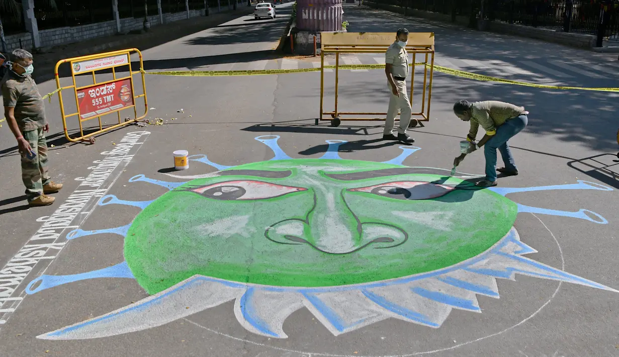 Seniman menggambar grafiti virus  corona di Bangalore (1/4/2020). Grafiti virus corona Covid-19 tersebut dibuat di semua persimpangan lalu lintas di Bangalore, India. (AFP/Manjunath Kiran)