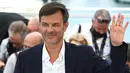 Francois Ozon tampil di sesi pemotretan Cannes Film Festival 2021 mengenakan setelan dari Dior Homme yang didesain oleh Kim Jones. Foto: Document/Dior.