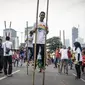 Peserta mendemokan ragam olahraga rekreasi TAFISA Games 2016 salah satunya Engrang di kawasan Car Free Day Thamrin, Jakarta, Minggu (25/9). Kegiatan itu mengajak masyarakat untuk kembali mengenal permainan tradisional. (Liputan6.com/Faizal Fanani)