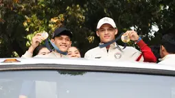 Peraih medali emas Olimpiade Paris 2024, Veddriq Leonardo (kiri) dan Rizki Juniansyah memamerkan medali saat melakukan pawai bersama sejumlah atlet dan ofisial Kontingen Indonesia lainnya menggunakan bus tingkat terbuka Transjakarta menuju Istana Negara, Jakarta Pusat, Kamis (15/8/2024). (Bola.com/Abdul Aziz)