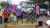 Ibu dan anak foto bersama di landmark Asian Festival 2018 di kawasan Gelora Bung Karno Senayan, Jakarta, Minggu (2/9). Jelang Closing Ceremony Asian Games 2018 calon penonton memadati komplek GBK. (Liputan6.com/Fery Pradolo)