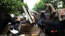 Petugas membuang barang milik warga di sepanjang jalan pascabanjir mulai surut di kawasan Kembangan, Jakarta Barat, Minggu (5/1/2020). Pasca banjir yang melanda hampir di kawasan Jakarta mulai surut, tumpukan sampah terlihat di sepanjang jalan dari rumah-rumah warga. (Liputan6.com/Johan Tallo)