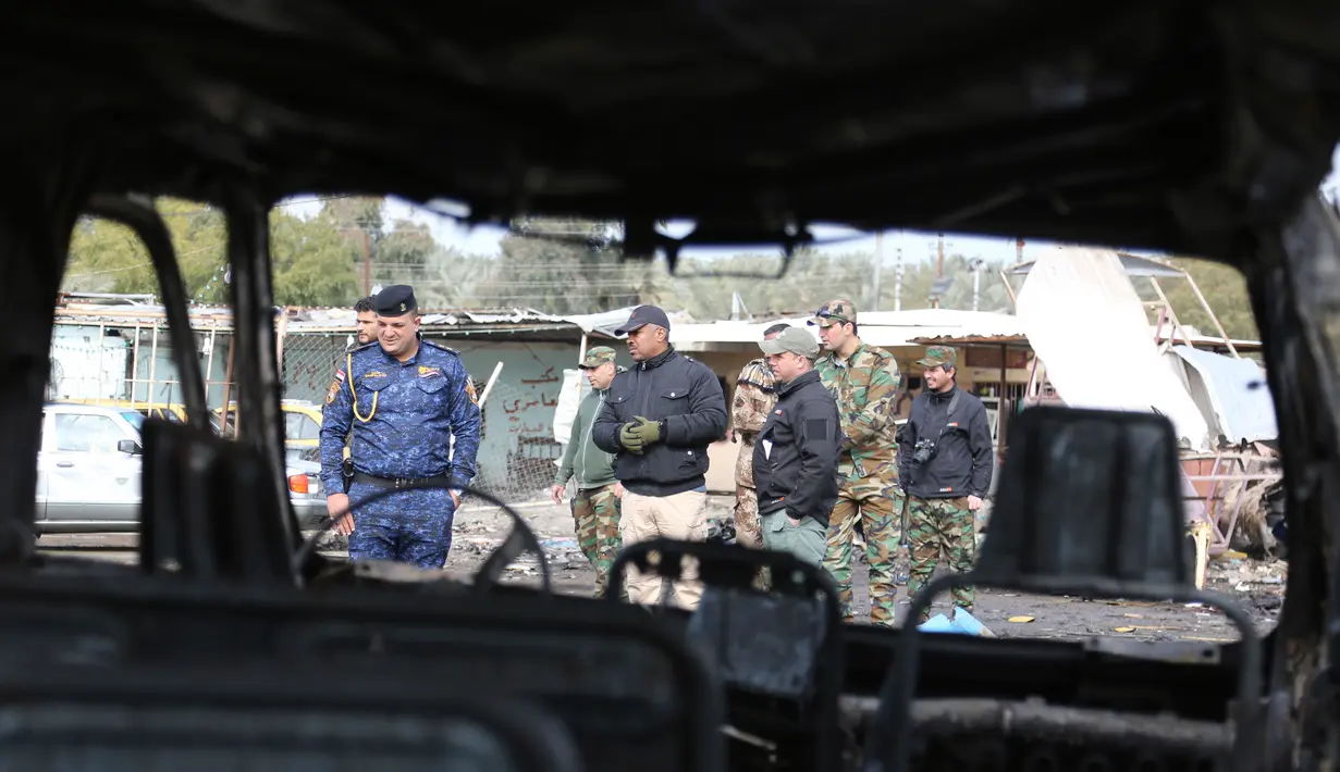 Petugas berada di sekitar lokasi tempat terjadinya serangan bom mobil di permukiman al-Bayaa, Irak, Kamis (16/2). Pihak keamanan dan sumber medis mengatakan sedikitnya 48 orang tewas dan melukai 55. (AP Photo/ Karim Kadim) 
