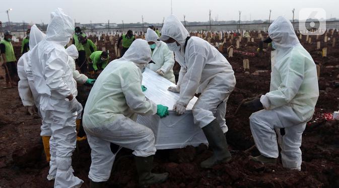 Petugas bersiap memakamkan jenazah dengan protokol Covid-19 di TPU Rorotan, Cilincing, Jakarta, Rabu (23/6/2021). Gubernur Provinsi DKI Jakarta Anies Baswedan mengatakan, hingga Rabu (23/6) 900 jenazah dimakamkam dengan protokol Covid-19 di TPU Rorotan. (Lipiutan6.com/Helmi Fithriansyah)