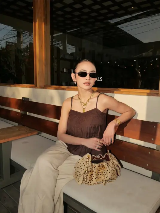 Pada salah satu penampilannya, Mahalini memilih nuansa earthy yang sedang tren. Ia mengenakan tank top cokelat dengan detail tekstur dan bordir yang memberikan sentuhan feminin tanpa terlihat berlebihan. Atasan tersebut dipadukan dengan celana longgar warna krem yang menciptakan siluet santai sekaligus effortless.