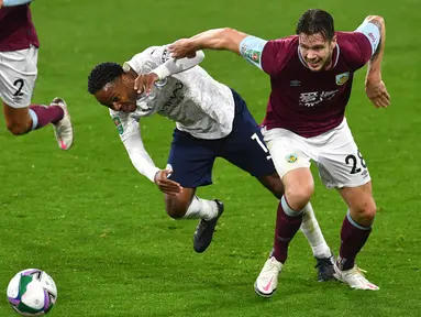 Penyerang Manchester City, Raheem Sterling berebut bola dengan pemain  Burnley, Kevin Long pada laga babak keempat Piala Liga Inggris di Turf Moor, Kamis (1/10/2020) dini hari WIB. Raheem Sterling mencetak dua gol saat Manchester City menang 3-0 atas Burnley. (Paul Ellis/Pool via AP)