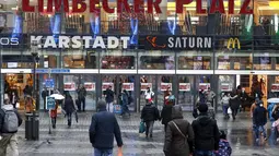Orang-orang berjalan ke pusat perbelanjaan di pusat Kota Essen, Jerman, Senin (14/12/2020). Jerman melakukan lockdown nasional pada 16 Desember 2020 untuk memerangi pandemi COVID-19. (AP Photo/Martin Meissner)