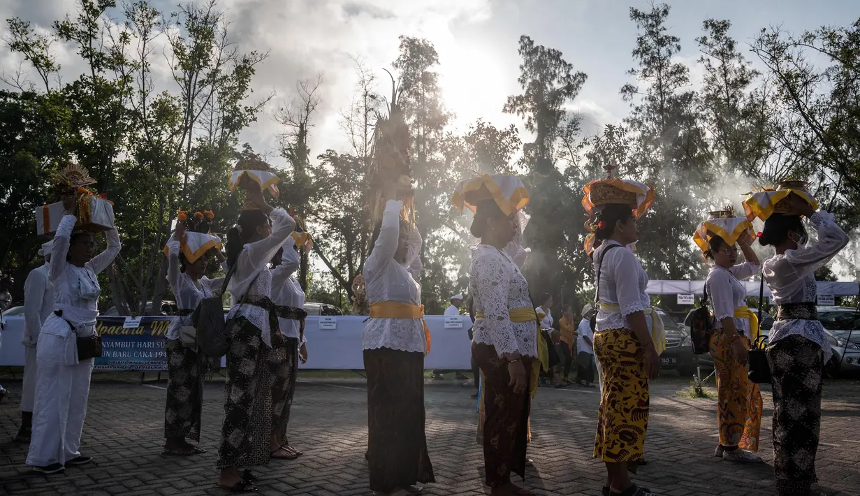 Orang-orang bersiap untuk mengambil bagian dalam doa upacara Melasti di Pura Segara di Surabaya, Jawa Timur, Minggu 19 Maret 2023. (Juni Kriswanto/AFP)