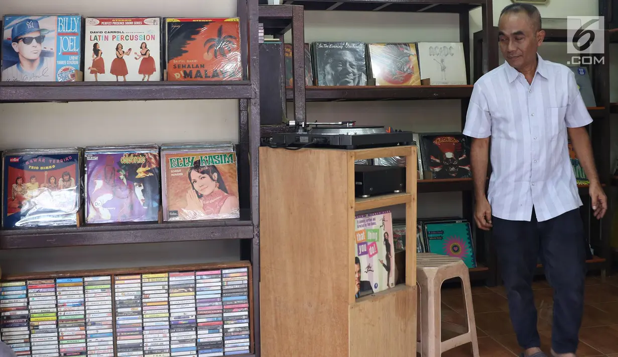 Iyan (56) mengecek piringan hitam atau vinyl dagangannya di Pasar Barang Bekas Jalan Surabaya, Jakarta, Selasa (30/5). (Liputan6.com/Immanuel Antonius)