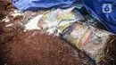 Barang diduga bansos presiden ditemukan tertimbun di kawasan Kampung Serab, Sukmajaya, Depok, Jawa Barat, Minggu (31/7/2022). Penemuan barang diduga bansos presiden untuk warga terdampak COVID-19 yang tertimbun dalam tanah itu terungkap setelah ahli waris pemilik lahan melakukan penggalian menggunakan alat berat. (Liputan6.com/Faizal Fanani)