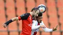 Pemain Paris Saint-Germain (PSG), Alessandro Florenzi, duel udara dengan pemain Lorient, Jerome Hergault, pada laga Liga Prancis di Stadion Moustoir, Minggu (31/1/2021). PSG takluk dengan skor 3-2. (AP/David Vincent)