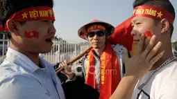 Suporter Vietnam saling membantu menempel logo bendera negaranya pada wajah masing-masing sebelum laga semifinal Piala AFF 2016 di Stadion Nasional My Dinh, (07/12/2016). (Bola.com/Peksi Cahyo)