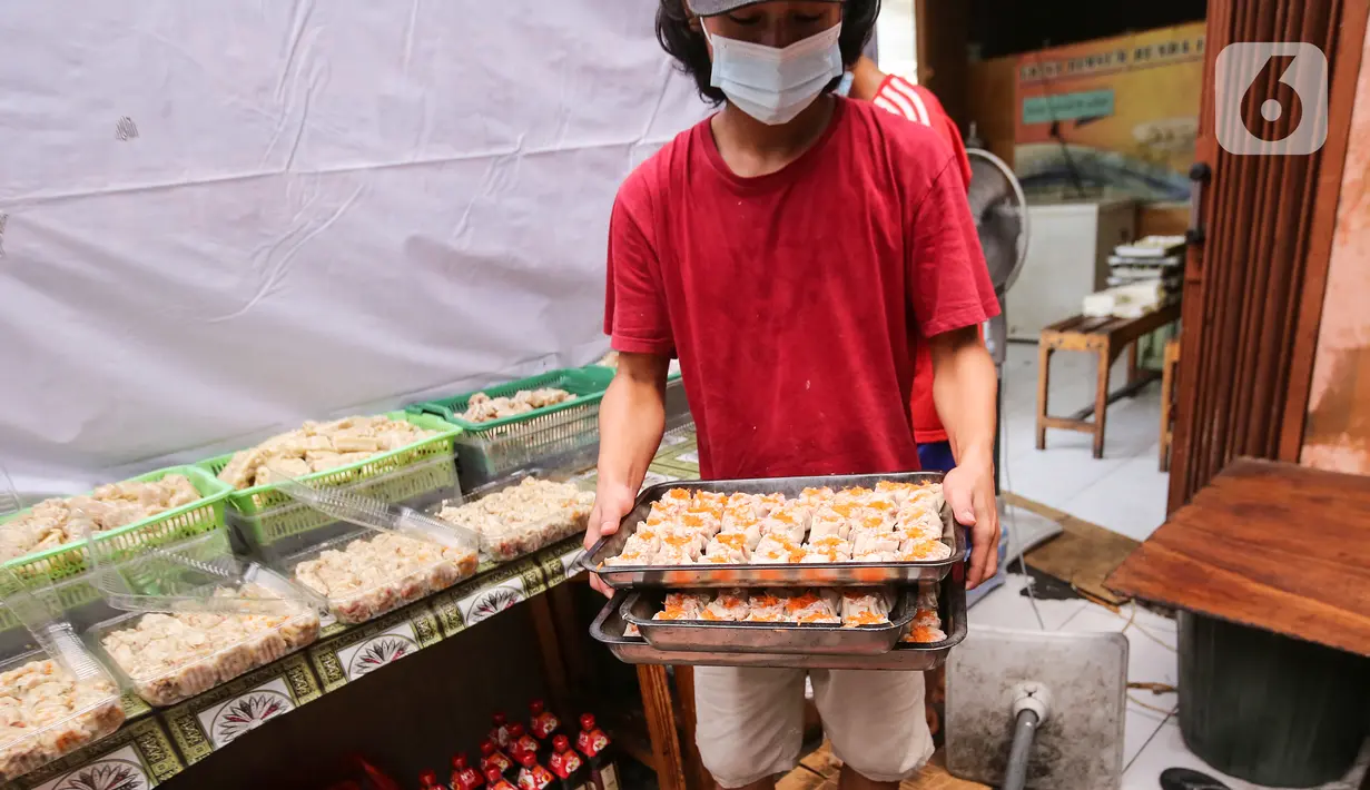 Karyawan membawa dimsum untuk kukus di Griya Dimsum Bunda Imoet, Serua, Tangerang Selatan, Rabu (9/2/2022). UMKM dimsum yang berdiri sejak tahun 2020 di awal pandemi mampu memproduksi lebih dari 100 pak atau lebih dari 1000 buah dimsum per hari. (Liputan6.com/Fery Pradolo)