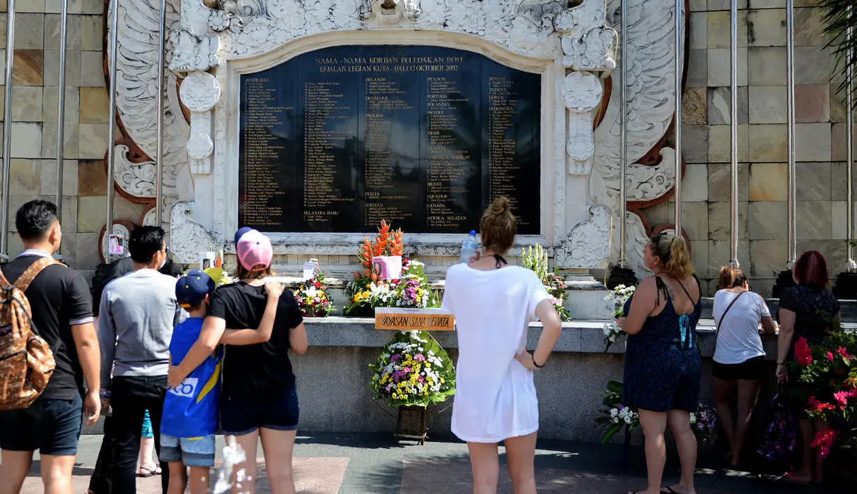 Sejumlah warga loka dan asing saat memperingati Tragedi Bom Bali I yang ke 14 di Monumen Ground Zero di Kuta, Bali, (12/10). Peristiwa ledakan bom di Jalan Legian ini merenggut 202 korban jiwa. (AFP Photo/ Sonny Tumbelaka)