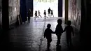 Sejumlah anak pengungsi bermain di sekitar Kamp Oinofyta, Athena, Yunani (13/3). Kamp ini merupakan rumah bagi para pengungsi atau imigran, terutama dari Afghanistan. (AFP Photo / Louisa Gouliamaki)