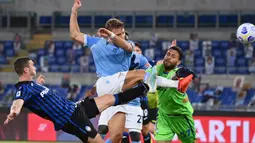 Striker bintang Lazio, Ciro Immobile (tengah) berebut bola dengan kiper Atalanta Marco Sportiello pada laga kedua Liga Italia Serie A di Stadion Olimpiade, Rabu (30/9/2020). Atalanta mampu menaklukkan tuan rumah Lazio dengan skor 4-1. (Alfredo Falcone/LaPresse via AP)