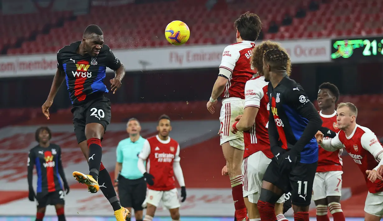 Striker Crystal Palace, Christian Benteke (kiri) melepaskan sundulan ke gawang Arsenal dalam laga lanjutan Liga Inggris 2020/21 di Emirates Stadium, Kamis (14/1/2021). Crystal Palace bermain imbang 0-0 dengan Arsenal. (AFP/Julian Finney/Pool)