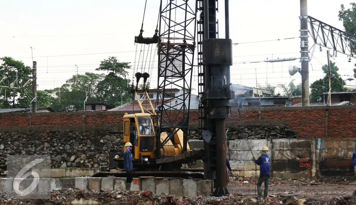 Pekerja menyelesaikan pekerjaannya di bantaran Kali Ciliwung, Bukit Duri, Jakarta (1/11). Pemasangan tiang pancang untuk sheet pile di kali tersebut telah mencapai 1300 meter, ditargetkan selesai akhir Desember 2016. (Liputan6.com/Gempur M Surya)