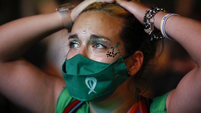 Ekspresi aktivis hak-hak aborsi saat menonton siaran langsung sidang parlemen di luar Kongres, Buenos Aires, Argentina, Rabu (30/12/2020). Argentina memastikan sebagai negara Amerika Latin pertama yang melegalkan aborsi. (AP Photo/Natacha Pisarenko)