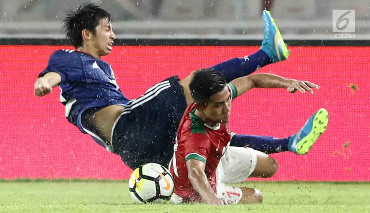 Dua pesepak bola Timnas Indonesia U-19 dan Jepang U-19 terjatuh saat berebut bola pada laga uji coba babak kedua di Stadion Utama GBK, Jakarta, Minggu (25/3). Timnas Indonesia menelan kekalahan 1-4 dari Jepang U-19. (Liputan6.com/Angga Yuniar)