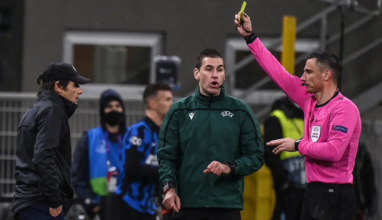 Pelatih Inter Milan, Antonio Conte, menerima kartu kuning dari wasit Slavko Vincic dalam laga lanjutan Liga Champions 2020/21 Grup B antara Inter Milan melawan Shakhtar Donetsk di San Siro Stadium, Rabu (9/12/2020). Inter Milan bermain imbang 0-0 dengan Shakhtar Donetsk. (AFP/Marco Bertorello)