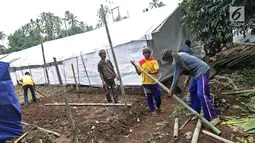 Pengungsi Gunung Agung menyusun bambu untuk membangun tenda di Posko Pengungsi Rendang, Bali, Sabtu (2/12). Mereka mendirikan tenda untuk tempat tinggal sementara. (Liputan6.com/Immanuel Antonius)