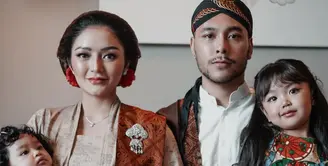 Siti Badriah dan Krisjiana Baharuddin mengajak kedua anaknya menghadiri sebuah acara pernikahan. Keluarga ini pun tampil dengan dress code Jawa sesuai dengan tema acara pernikahan. [@sitibadriahh]