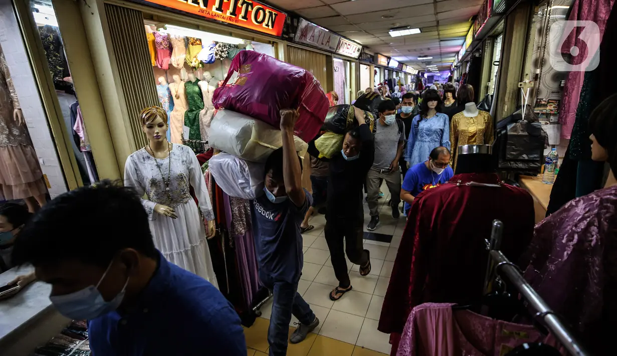 Aktivitas pekerja di Pasar Tanah Abang, Jakarta, Selasa (6/4/2021). Menjelang bulan Ramadan, Pasar Tanah Abang mulai dipadati pengunjung untuk berbelanja busana, namun menurut pedagang jumlah pengunjung bulan Ramadan kali ini tidak seramai sebelum pandemi Covid-19. (Liputan6.com/Johan Tallo)