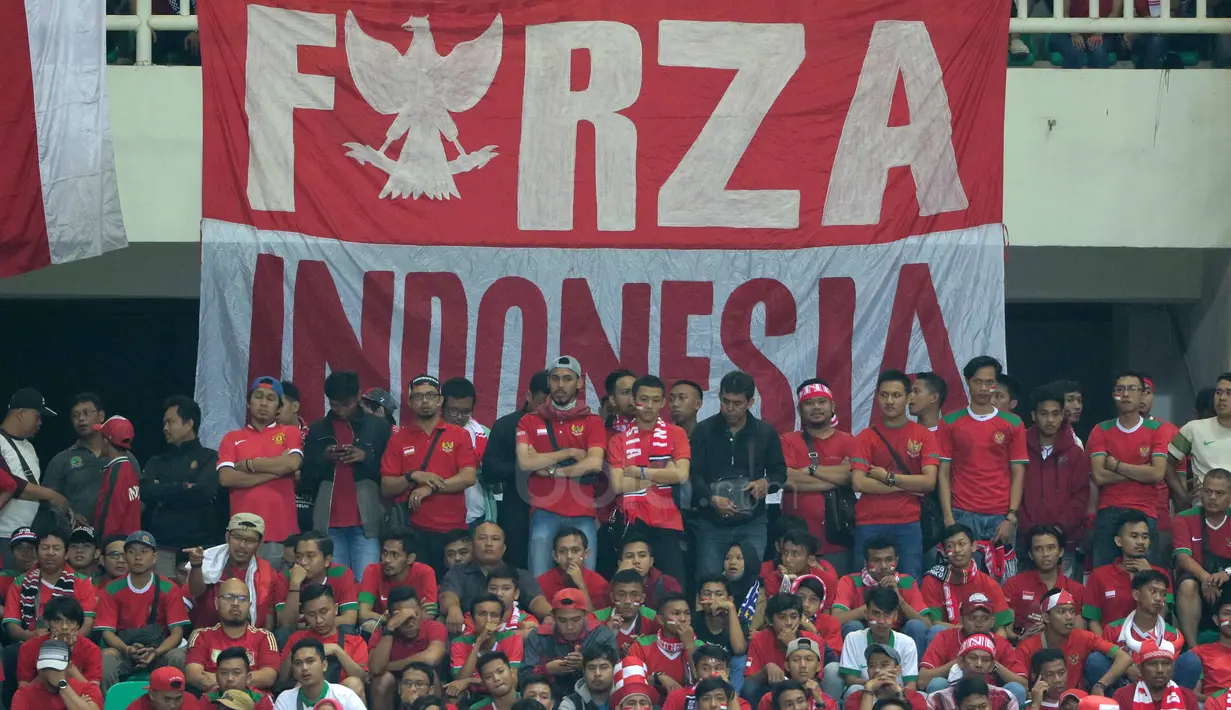 Gaya suporter saat mendukung Timnas Indonesia melawan Vietnam pada laga Semifinal AFF Cup 2016 di Stadion Pakansari, Bogor, (03/12/2016). (Bola.com/Nicklas Hanoatubun)