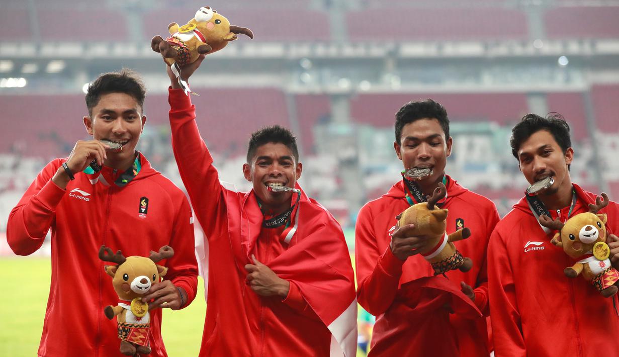 Lalu Muhammad Zohri (dua kanan) bersama Fadlin, Eko Rimbawan, dan Bayu Kertanegara menunjukkan medali perak usai bertanding di final lari 4x100 meter cabang olahraga atletik Asian Games 2018 di Jakarta, Kamis (30/8). (AP Photo/Bernat Armangue)